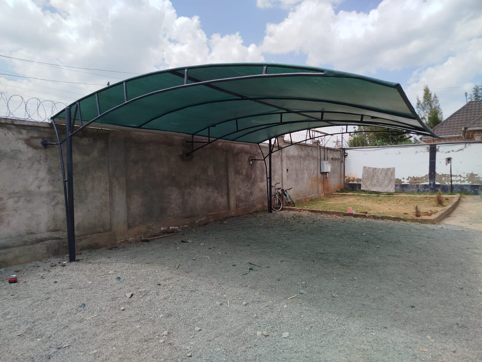 Finished white steel-arch car parking shade structure at a Nairobi property